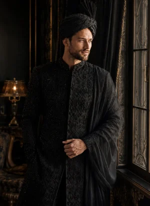 Groom wearing a black sherwani with a matching turban and shawl