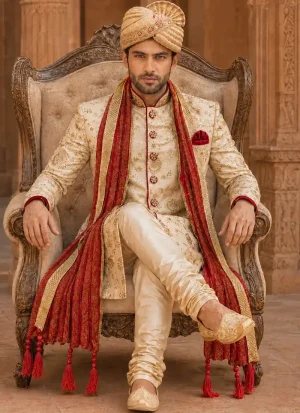 Ivory groom sherwani with gold embroidery, red shawl and matching turban