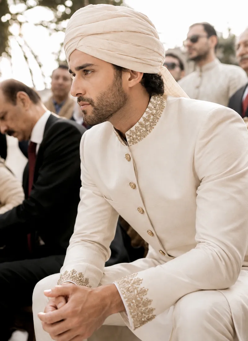 Hand-embroidered gold zari on the high stand collar of a white sherwani