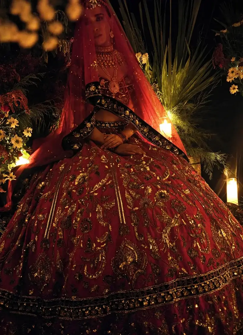 Crimson red bridal lehenga paired with a black velvet blouse and intricate antique zardozi embroidery