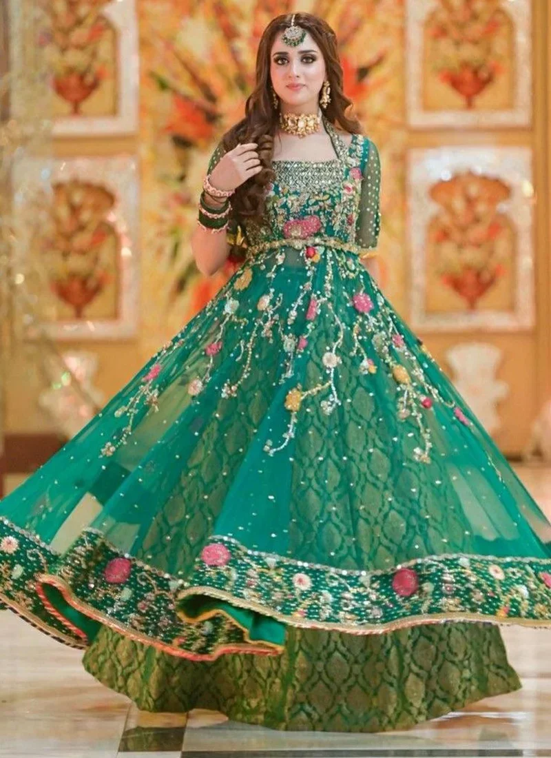 Emerald green bridal Pishwas paired with a lehenga and detailed crystal embellishments