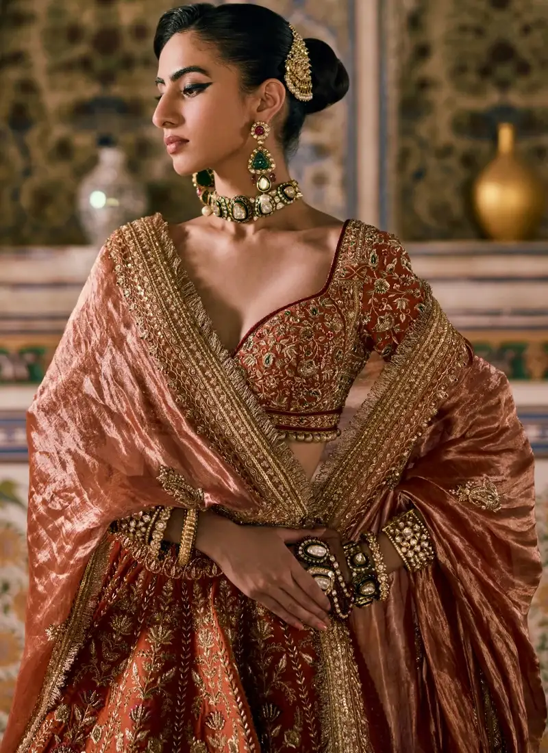 Indian bridal lehenga choli in rust brown with intricate resham embroidery and zardozi detailing