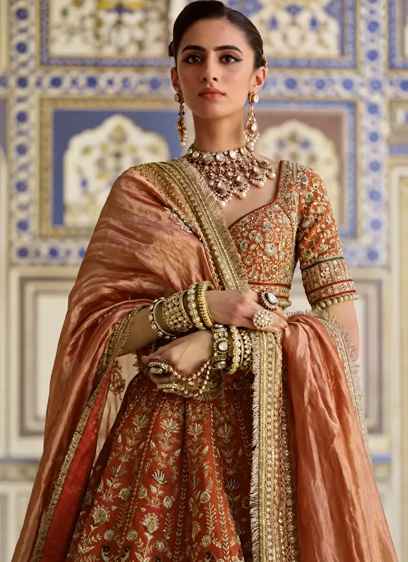 Traditional rust brown bridal lehenga with ornate zardozi resham embroidery and graceful wedding styling
