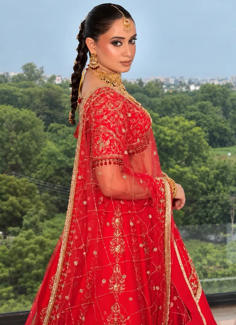 Traditional scarlet red bridal lehenga choli with gold paisley work and elegant beaded blouse detailing