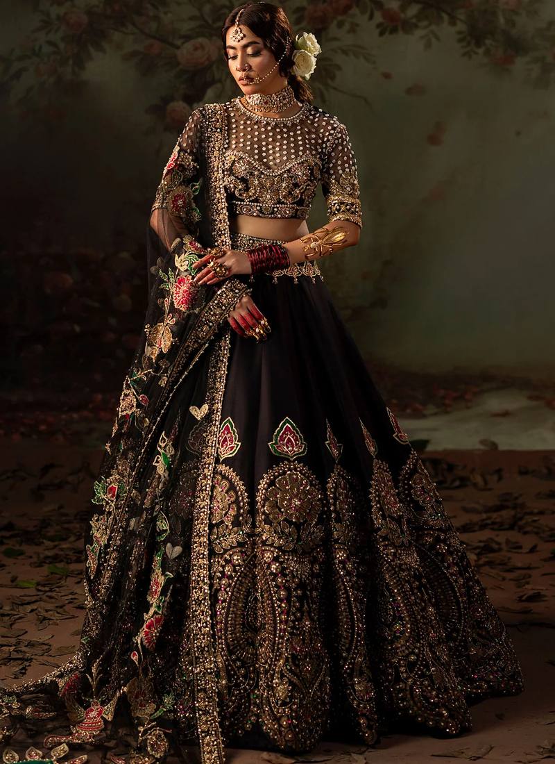 Black bridal lehenga choli front full-length view with pink-green paisley motifs above gold floral hem