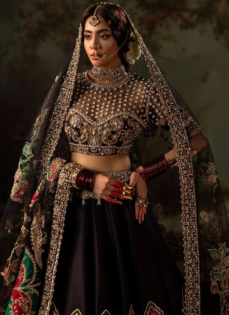 Black lehenga choli front view beneath gold-bordered dupatta with embroidered floral lehenga hem