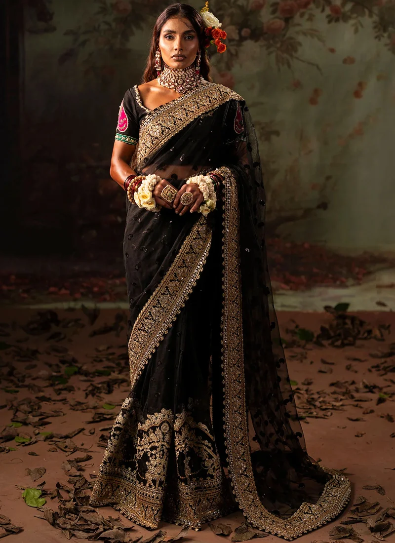Black saree and short-sleeved blouse, waist-up front view, with pink and green sleeve appliqué.