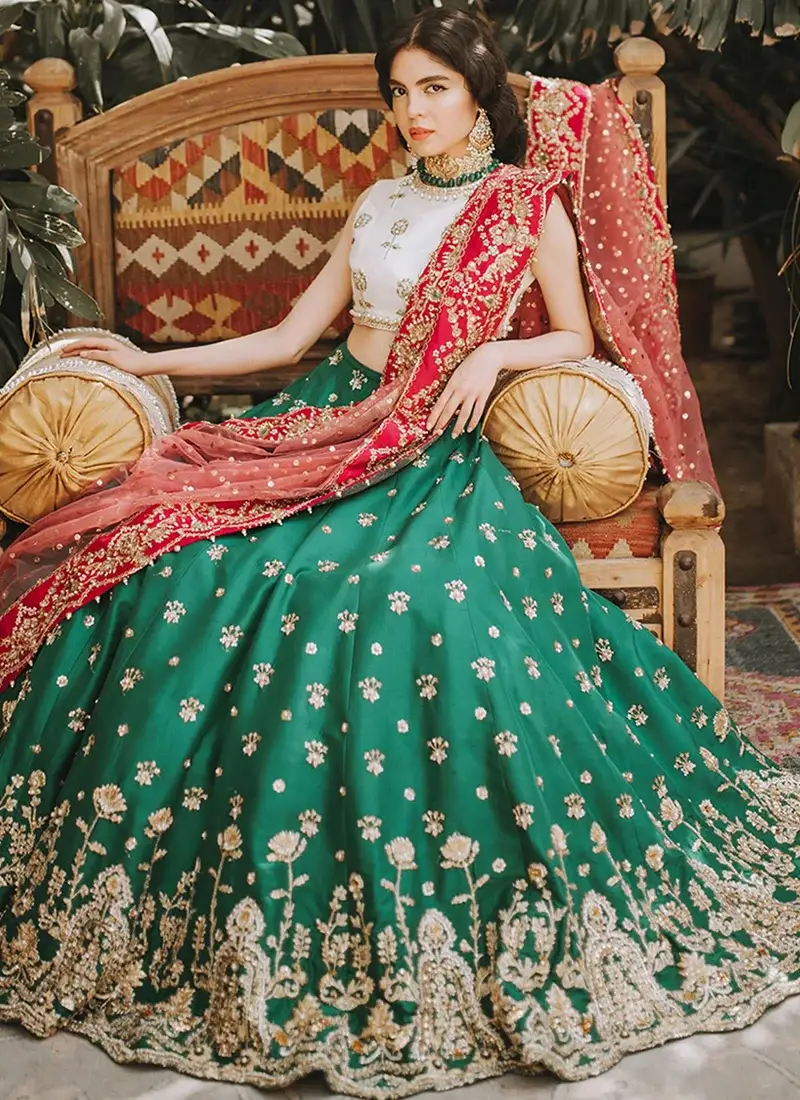 White sleeveless raw silk choli close-up with gold floral motifs beneath sheer dotted pink net