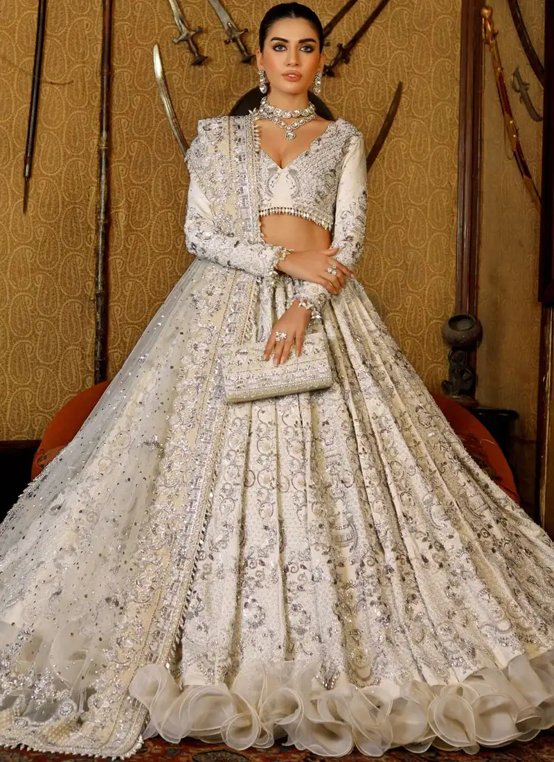 Ivory Walima Lehenga Choli with Organza Ruffle Hem Ivory lehenga choli front close-up with silver jaal embroidery, pearl-drop fringe and bordered net dupatta.