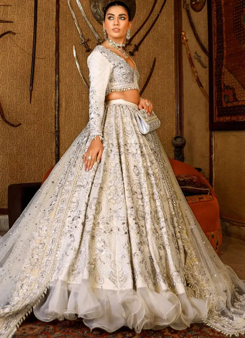Ivory lehenga choli rear view with sweeping embroidered skirt, sheer net dupatta and organza ruffle hem.