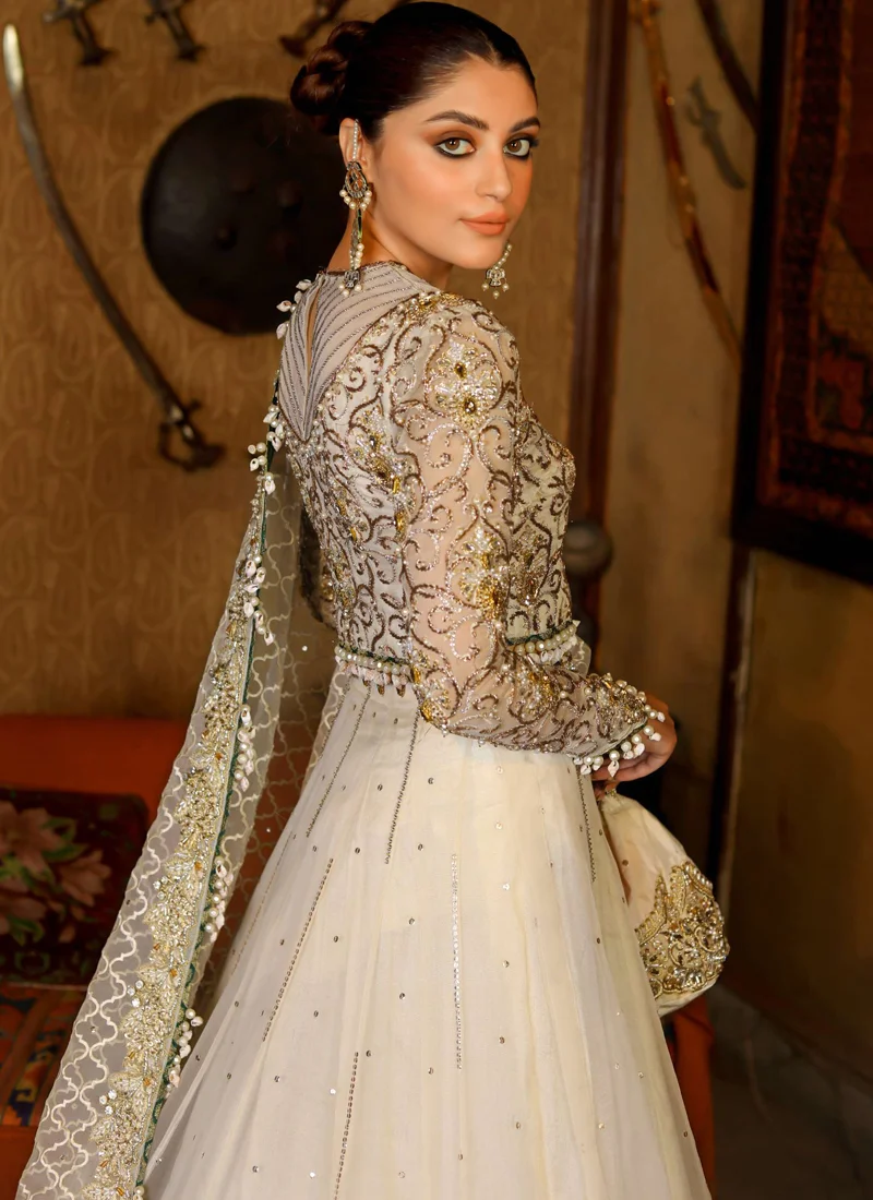 Ivory lehenga choli rear three-quarter view with V-shaped embroidered back panel and pearl-edged dupatta