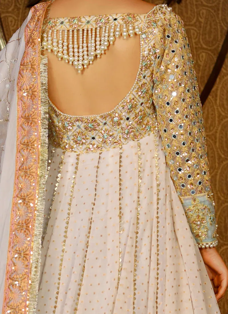 Off white bridal pishwas side view showing gold-dotted flare, mirror-work sleeves and bordered dupatta