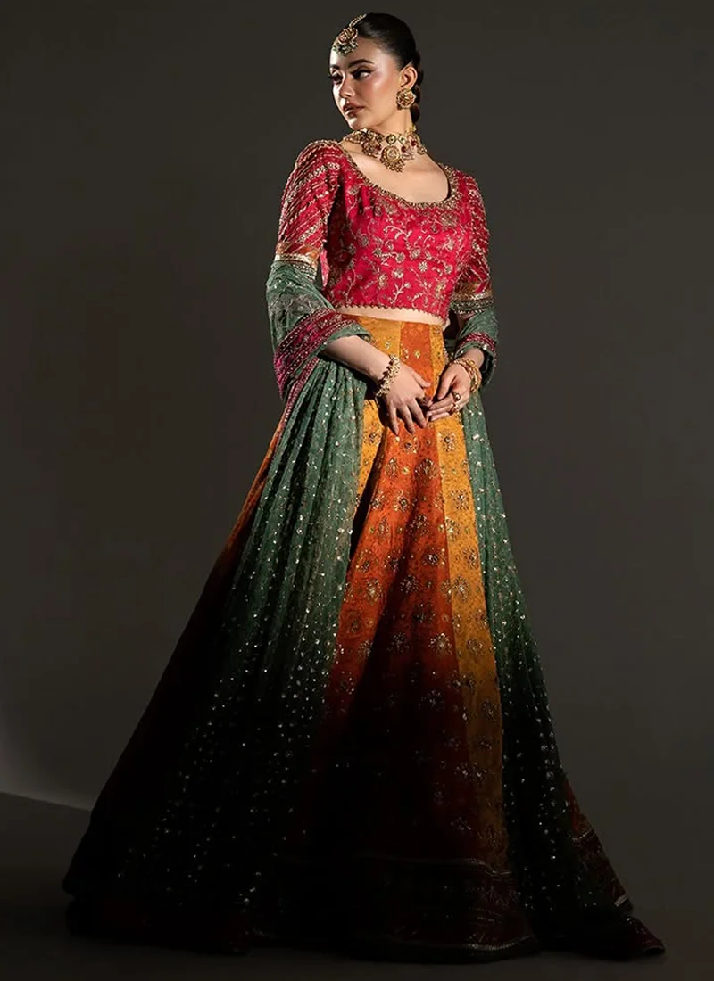 Orange and gold Mehndi lehenga choli with pink embroidered blouse, alternating skirt panels and ornate gold hem