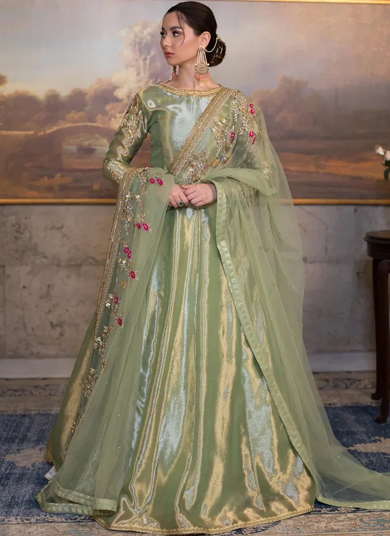 Pistachio Green Wedding Guest Anarkali Suit with Fuchsia Floral Vines Pistachio green pishwas, three-quarter view with ornate gold cuffs and fuchsia floral embroidery