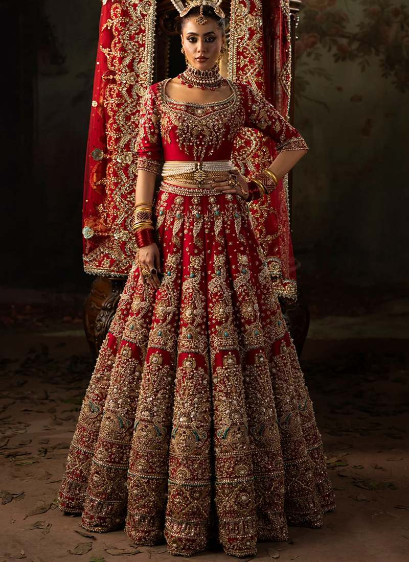 Red bridal lehenga choli front view with gold floral embroidery and turquoise accented hem medallions