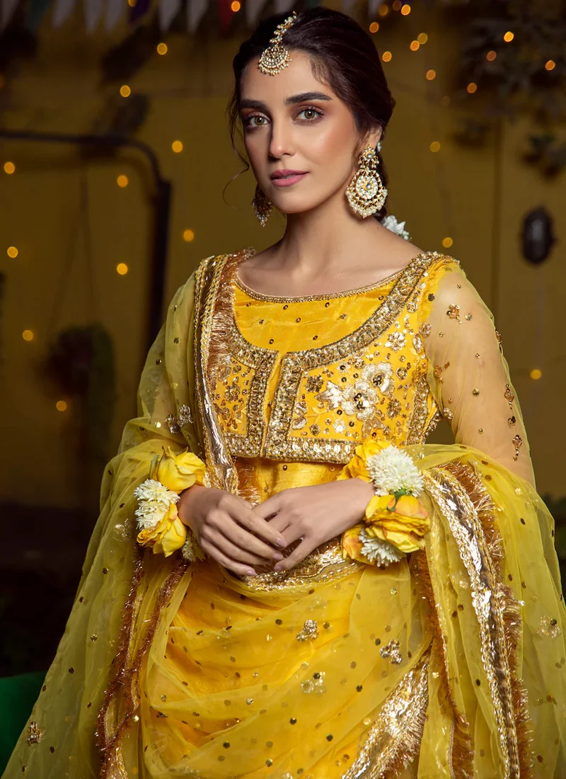 Yellow mehndi gharara suit rear full-length view showing gathered gharara flare and gold-edged net dupatta